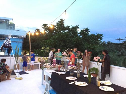 a group of people standing around a table on a patio at The VRNON Boutique by MY hostel in Boracay