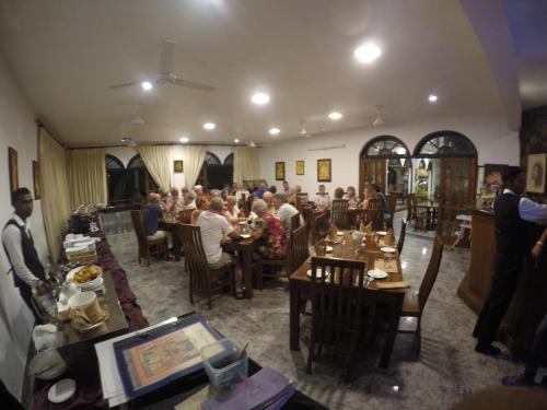 un grupo de personas sentadas en mesas en un restaurante en Hotel Sunray, en Kandy