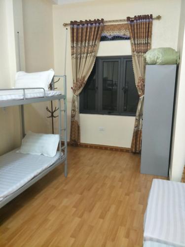 a room with two bunk beds and a window at Ngan Ha Homestay in Ha Giang