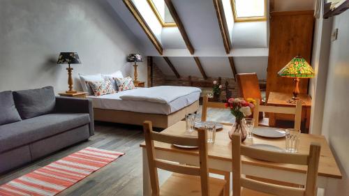 uma sala de estar com uma cama e uma mesa de jantar em Windmill Studios by Rembrandt Hotel em Bucareste