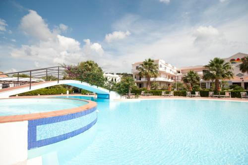 a large swimming pool in a resort with buildings at Oasiclub Hotel - Appartamenti in Vieste