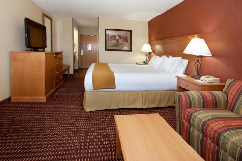 een hotelkamer met een groot bed en een bank bij Holiday Inn Express Hotel & Suites Raton, an IHG Hotel in Raton