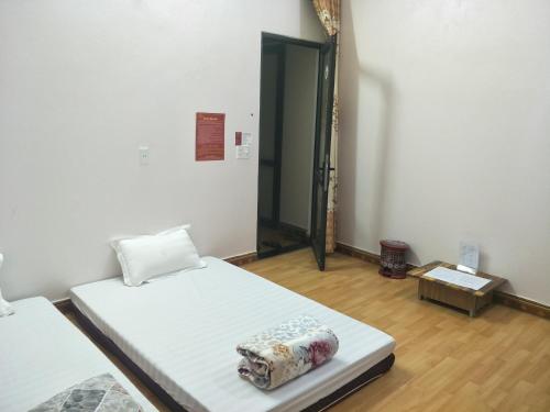 a room with two beds and a door in it at Ngan Ha Homestay in Ha Giang