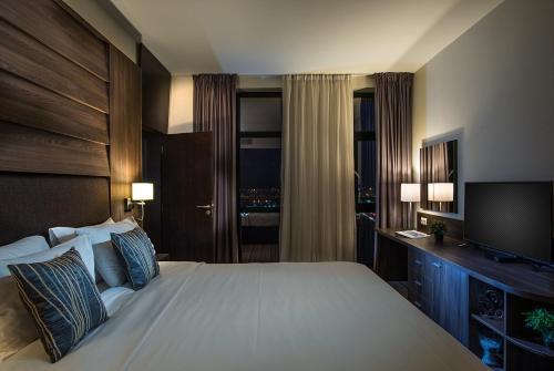 a hotel room with a bed and a television at Premier Sofia Airport Hotel in Sofia