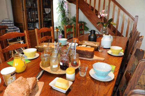una mesa de madera con comida encima en Chambres d'hôtes " Moulin du Couedic ", en Nivillac
