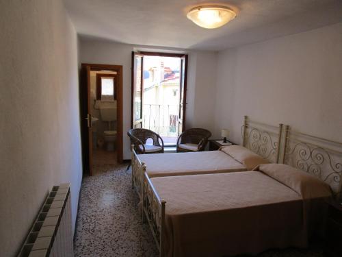 a bedroom with two beds and a door to a bathroom at Appartamento Da Loreno in Cutigliano