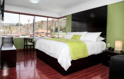 1 dormitorio con 1 cama grande y ventana grande en Casa Hotel Achumani, en La Paz