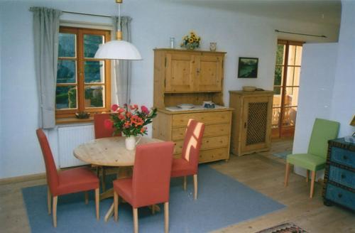 a dining room with a table and chairs and a kitchen at Sonnwirtstöckl am See in Sankt Gilgen