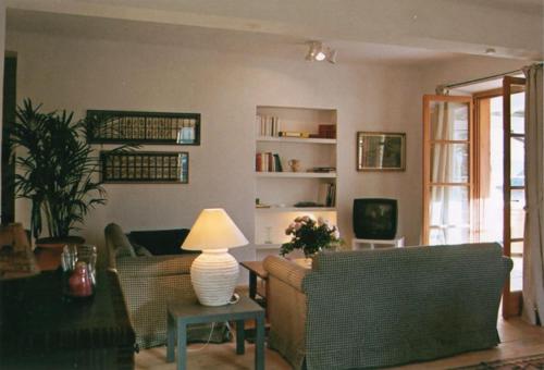 a living room with couches and a table with a lamp at Sonnwirtstöckl am See in Sankt Gilgen