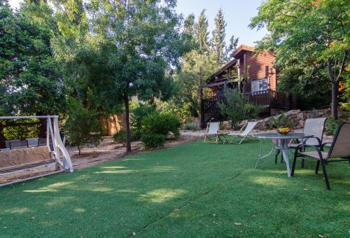 a yard with a table and chairs and a house at Mazal shell Zimmer in Amirim