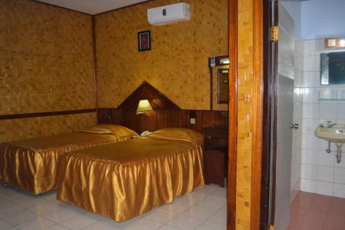 a hotel room with two beds and a sink at Hotel Indra Toraja in Rantepao
