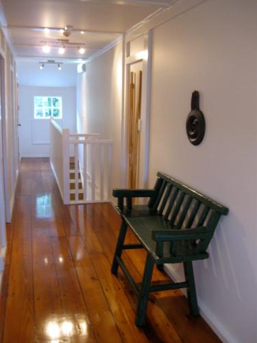 a green bench sitting in a room with a hallway at The Old Oak Boutique Hotel in Mangonui