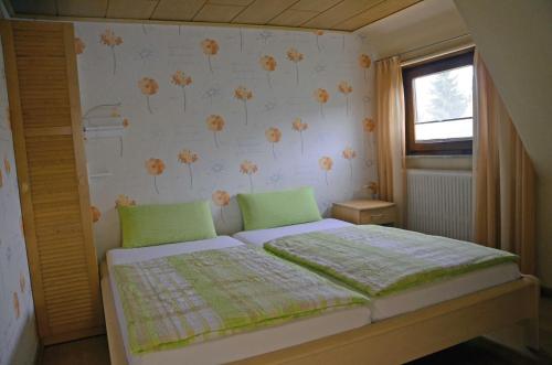 a bedroom with a bed with a flower pattern on the wall at Ferienwohnung Westphal in Eschwege