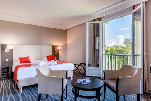 een hotelkamer met 2 bedden en een balkon bij Logis Hôtels- Hôtel et Restaurant Domaine de Fompeyre in Bazas