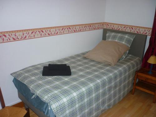 a bed with a black bag on top of it at Maison dans la cité médiévale de Domme in Domme