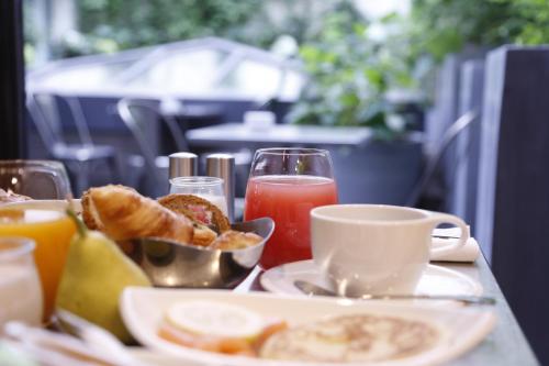 a table with a plate of breakfast food and drinks at Boutet Bastille Hotel Paris - MGallery Collection in Paris