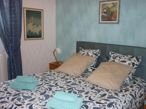 a bed with two blue towels on top of it at Maison dans la cité médiévale de Domme in Domme