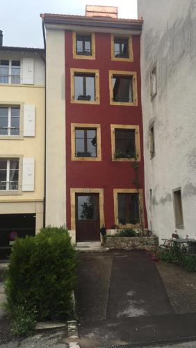 a red building with a fire hydrant in front of it at LaMaisonRouge chambre d'hôtes in Cormondreche