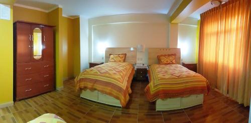 a bedroom with two beds and a dresser at Morales Guest House in Huaraz