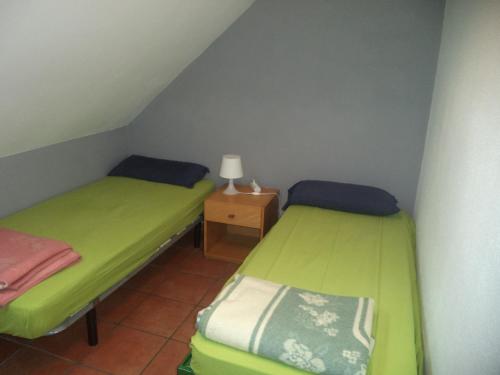 a small room with two beds and a night stand at Albergue de Canfranc Estación in Canfranc-Estación