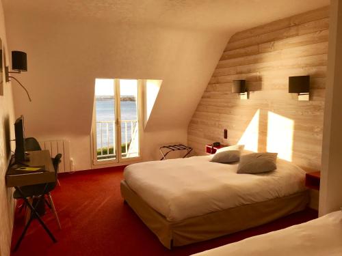 Saint-Guénoléにあるル ステーレンのベッド2台と窓が備わるホテルルームです。