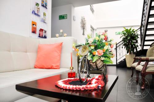 a living room with a white couch and a table at Hotel Parque Santander Tunja in Tunja