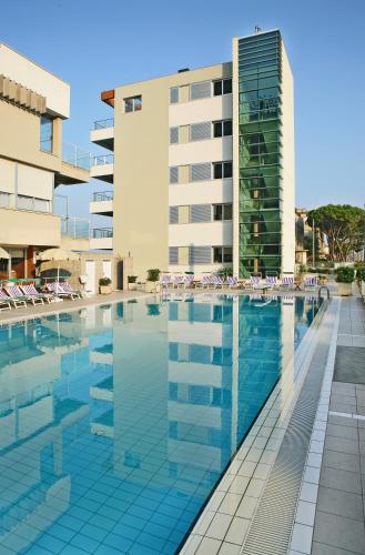 a swimming pool in front of a building at Hotel Ascot & Spa in Rimini