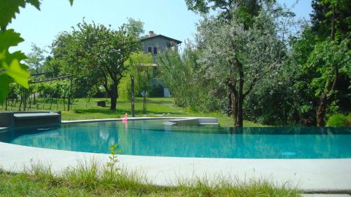 バルドリーノにあるCasa dei Saliciの木々と家の庭のスイミングプール