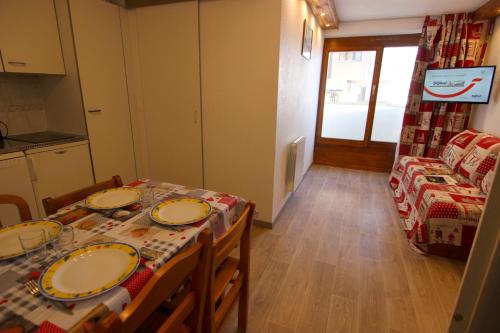 a dining room with a table with plates on it at Altineige Appartements VTI in Val Thorens