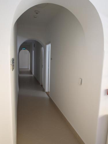 an empty hallway with white walls and an archway at Ciszterci Szállás Pécs in Pécs