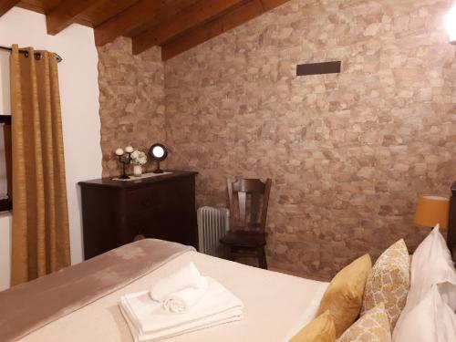 a bedroom with a bed and a stone wall at Casinha do México in Gondramaz