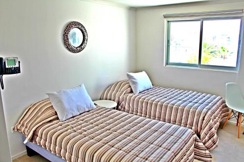 a bedroom with two beds and a window at Playa Hotel - Cavancha in Iquique