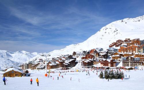 a group of people skiing on a snow covered mountain at Altineige Appartements VTI in Val Thorens