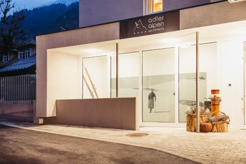 a store front with large glass windows with a woman in the reflection at adler alpen apartments in Schruns