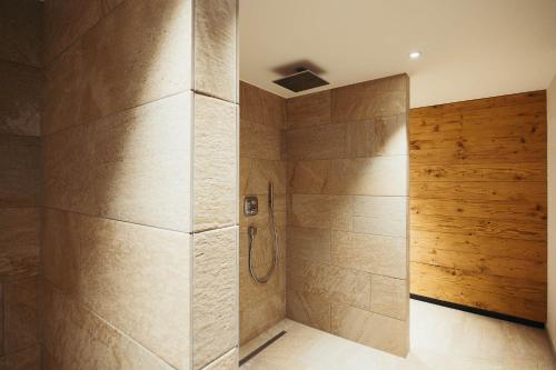 a shower in a bathroom with wooden walls at adler alpen apartments in Schruns