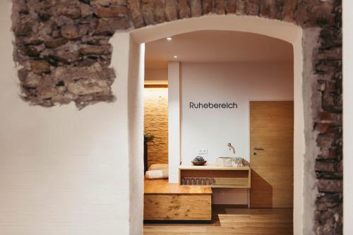 a hallway to a room with a table and a wall at adler alpen apartments in Schruns