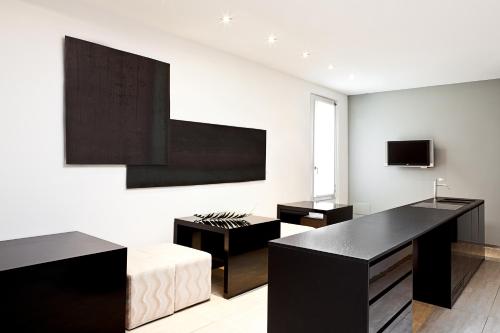 a living room with black furniture and a tv at Muà in Bologna