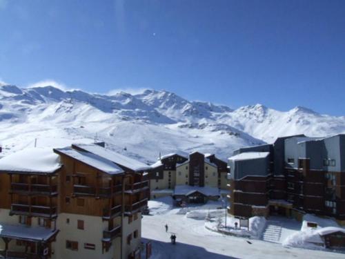 a group of buildings in front of a snow covered mountain at Altineige Appartements VTI in Val Thorens