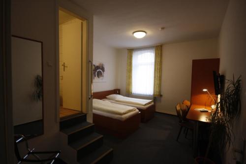 ein Hotelzimmer mit 2 Betten und einer Treppe in der Unterkunft Hotel-Gaststätte Mutter Buermann in Hemmingen