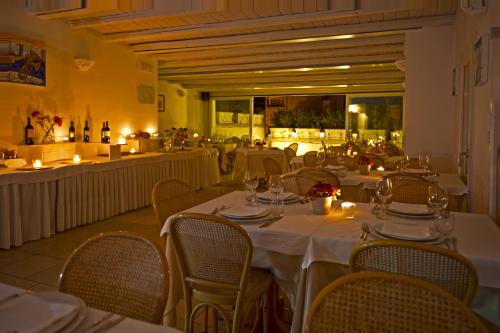 a restaurant with white tables and chairs and candles at Hotel Corte Altavilla in Conversano