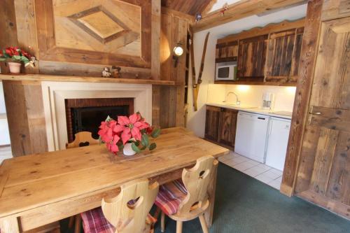 une cuisine avec une table en bois et une cheminée dans l'établissement Diamant Appartements VTI, à Val Thorens