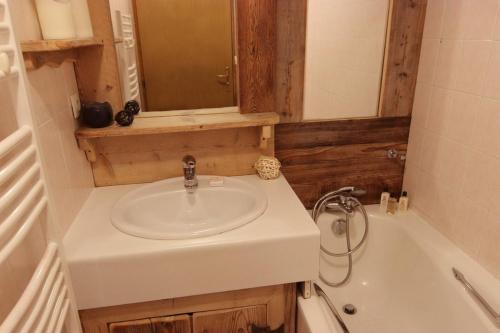 une salle de bain avec un lavabo et une baignoire dans l'établissement Diamant Appartements VTI, à Val Thorens