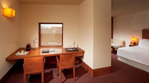a hotel room with a desk and a bed at Hotel Meliá Bilbao in Bilbao