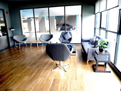 a living room with couches and chairs and windows at ZcapeX2 in Bang Tao Beach