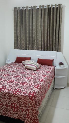a bedroom with a red and white bed with a curtain at Mar Azul in Solemar