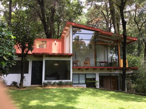 a house with a red roof and a yard at Refugio en el bosque de agua en Cuernavaca in Cuernavaca