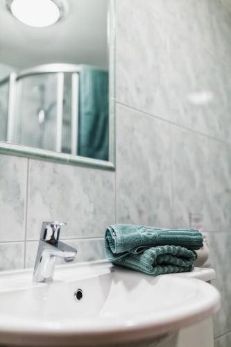 a green towel sitting on top of a bathroom sink at Naturpension Mühlhof in Neukirchen am Großvenediger