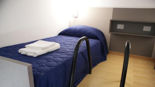 Bett mit blauer Decke in einem Zimmer in der Unterkunft Departamento Estudio 1 in Neuquén