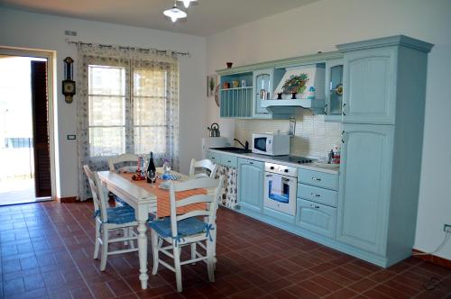 kuchnia z niebieskimi szafkami i stołem z krzesłami w obiekcie Agriturismo La Spiga w mieście Montecatini Val di Cecina