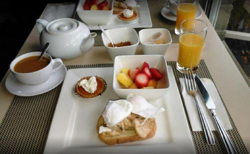 una mesa con una bandeja de alimentos y bebidas para el desayuno en Orchid Inn, en Niagara on the Lake